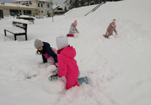 dziewczynki bawią się na śniegu